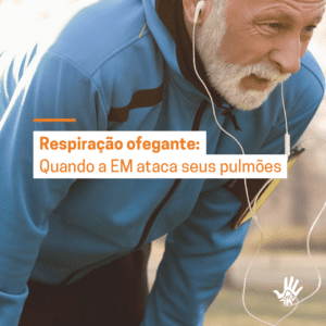 homem branco de camisa de botão azul escura, barba branca, inclinado para frente com as mãos nos joelhos