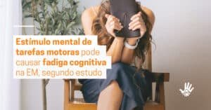 Mulher sentada, com as pernas cruzadas em cadeira de madeira. Ela veste blusa branca, saia jeans, relógio branco no braço esquerdo e cabelos longos e castanhos. Apoia os dois cotovelos no joelho e esconde o rosto nos braços, segurando uma agenda de couro. À esquerda, a frase "Estímulo mental de tarefas motoras pode causar fadiga cognitiva na EM, segundo estudo".