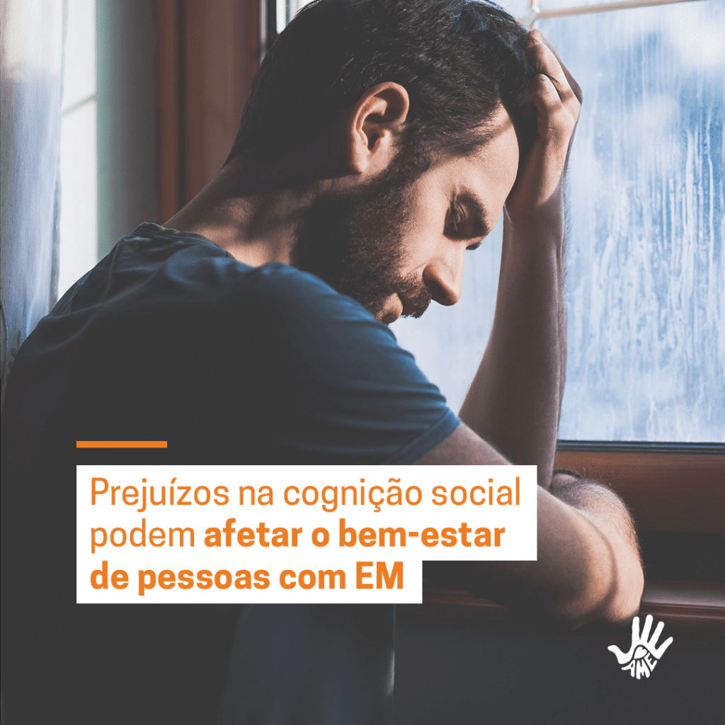 Homem de camisa azul está na frente de uma janela, com a cabeça baixa encostada em sua mão esquerda. O outro braço encontra-se dobrado em sua frente. No texto em laranja e fundo branco,lê-se "Prejuízo na cognição social podem afetar o bem-estar de pessoas com EM".